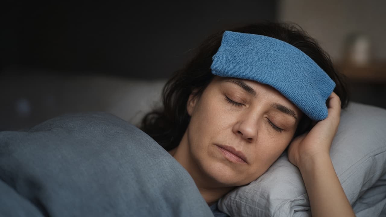 Cool compress on forehead in a dim quiet room