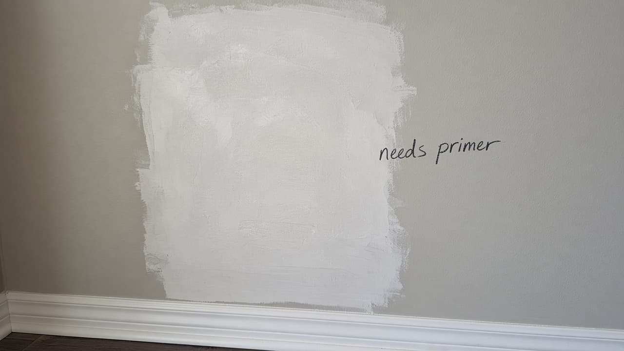 Bare drywall patch marked needs primer beside sound painted wall