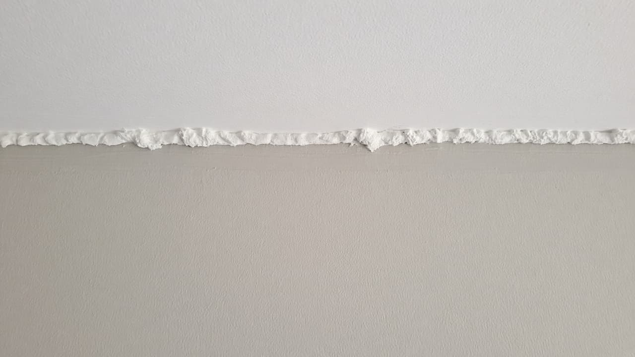 Heavy brush ridge at ceiling marked as mistake to feather out